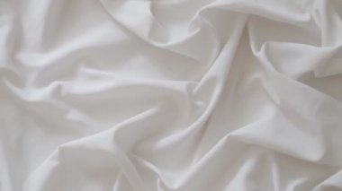 White fabric. Drapery wavy texture white linen cloth background on morning sunshine. Clean clothes concept. High quality FullHD footage