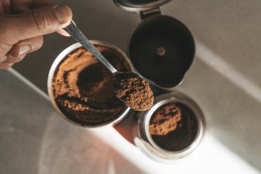 Ocakta espresso demlemek için metal kahve makinesi. Kahve çekirdekli çay kaşığı. Yüksek kalite fotoğraf