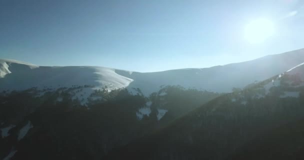 Scatto aereo di maestosa alba in montagna. La valle tra le montagne è coperta di nebbia ed è illuminata dai caldi raggi del sole che sorge. Montagne coperte di foresta naturale. — Video Stock