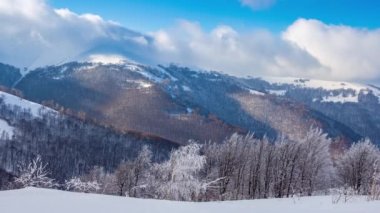 Yüksek Dağlar Tepeleri 'nin Manzaralı Hava Görüntüsü. Güneşli Kış Günü 'nde destansı manzara. Blue Sky, Fog ve Snow 'la hızlandırılmış video. Ukrayna 'daki Karpat Dağı' nın 4K Arka plan Çekimi
