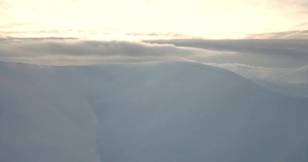 空中拍摄山中壮观的日出.高山之间的山谷被雾覆盖着，被升起的太阳的温暖光芒照亮着。森林覆盖的山脉. — 图库视频影像