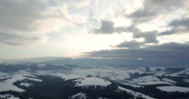 Dağlarda görkemli bir gündoğumu görüntüsü. Dağlar arasındaki vadi sisle kaplıdır ve yükselen güneşin sıcak ışınlarıyla aydınlanır. Dağlar doğal ormanlarla kaplı..