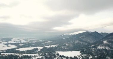 Dağlarda görkemli bir gündoğumu görüntüsü. Dağlar arasındaki vadi sisle kaplıdır ve yükselen güneşin sıcak ışınlarıyla aydınlanır. Dağlar doğal ormanlarla kaplı..