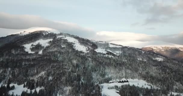 Foto aérea de majestuoso amanecer en las montañas. Valle entre las montañas está cubierto de niebla y está iluminado por los cálidos rayos del sol naciente. Montañas cubiertas de bosque natural. — Vídeos de Stock