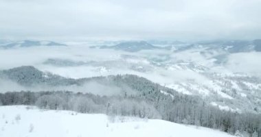 Peri masallarındaki dağ manzarasından. Alp sivri tepeleri karla kaplanmış. Ukrayna, Karpat dağlarında vahşi kış. Kalın beyaz bulutlar. Açık alan. Hava 4K
