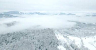 Peri masallarındaki dağ manzarasından. Alp sivri tepeleri karla kaplanmış. Ukrayna, Karpat dağlarında vahşi kış. Kalın beyaz bulutlar. Açık alan. Hava 4K