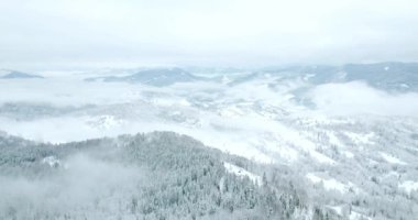Peri masallarındaki dağ manzarasından. Alp sivri tepeleri karla kaplanmış. Ukrayna, Karpat dağlarında vahşi kış. Kalın beyaz bulutlar. Açık alan. Hava 4K