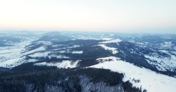 Desde gran altura cuento de hadas montaña paisaje nevado cubierto de picos agudos alpinos. Invierno salvaje en las montañas Cárpatas, Ucrania. Nubes blancas gruesas. Espacio abierto. Aéreo 4K — Vídeo de stock