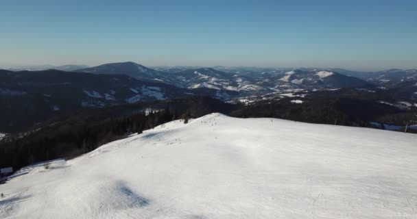 Desde gran altura cuento de hadas montaña paisaje nevado cubierto de picos agudos alpinos. Invierno salvaje en las montañas Cárpatas, Ucrania. Nubes blancas gruesas. Espacio abierto. Aéreo 4K — Vídeo de stock