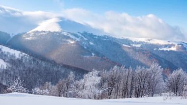 Yüksek Dağlar Tepeleri 'nin Manzaralı Hava Görüntüsü. Güneşli Kış Günü 'nde destansı manzara. Blue Sky, Fog ve Snow 'la hızlandırılmış video. Ukrayna 'daki Karpat Dağı' nın 4K Arka plan Çekimi