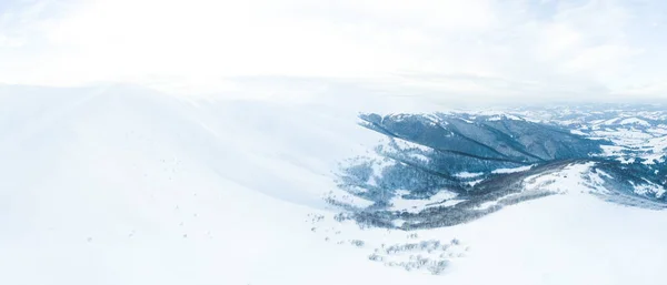 Foto aérea de majestuoso amanecer en las montañas. Valle entre las montañas está cubierto de niebla y está iluminado por los cálidos rayos del sol naciente. Montañas cubiertas de bosque natural. —  Fotos de Stock