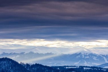 Karla kaplı dağ zirvesi rüzgarla esiyor. Kış manzarası. Soğuk bir gün, karlı..