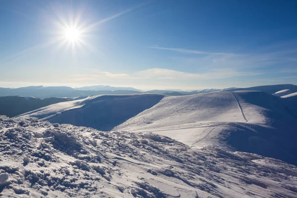 Belo panorama de inverno com neve fresca em pó. Paisagem com árvores de abeto, céu azul com luz solar e altas montanhas dos Cárpatos no fundo — Fotografia de Stock