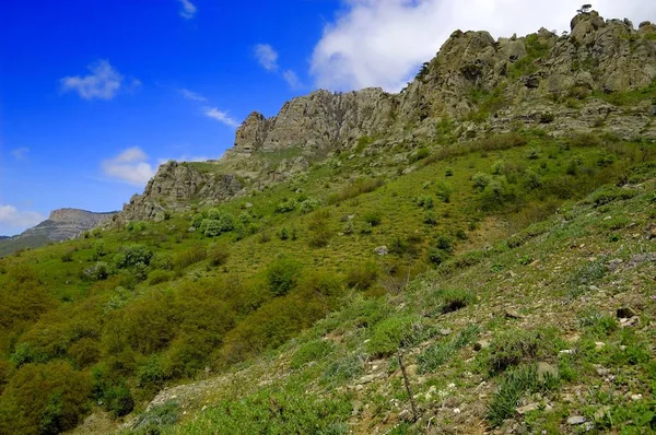 Fondo horizontal con un magnífico paisaje de la península de Crimea. Vista superior de las montañas cubiertas de exuberante vegetación y las densas nubes debajo de los picos. Cielo azul claro. Copiar espacio. —  Fotos de Stock