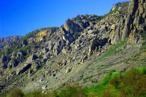 Fondo horizontal con un magnífico paisaje de la península de Crimea. Vista superior de las montañas cubiertas de exuberante vegetación y las densas nubes debajo de los picos. Cielo azul claro. Copiar espacio. — Foto de Stock
