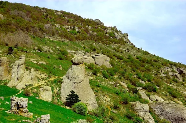 Sfondo orizzontale con un magnifico paesaggio della penisola di Crimea. Vista dall'alto delle montagne ricoperte di verde lussureggiante e le spesse nuvole sotto le cime. Cielo blu chiaro. Copia spazio. — Foto Stock