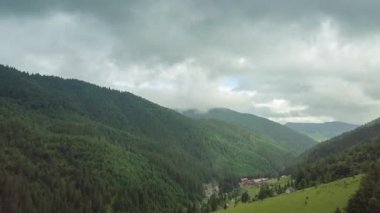 Dağ zirveleri ve sabah bulutları pürüzsüz hareket ediyor. Karpat Dağları 'nın çayırlarındaki yaz manzaralı vadi ağaçları. Ukrayna.