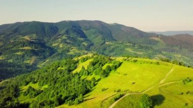 Karpatlar 'ın uçsuz bucaksız otlaklarının ve tarım arazilerinin havadan görünüşü. Tarım tarlası. Gün batımında kırsal dağ manzarası. Ukrayna.
