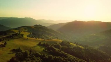 Karpatlar 'ın uçsuz bucaksız otlaklarının ve tarım arazilerinin havadan görünüşü. Tarım tarlası. Gün batımında kırsal dağ manzarası. Ukrayna.