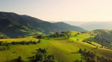 Karpatlar 'ın uçsuz bucaksız otlaklarının ve tarım arazilerinin havadan görünüşü. Tarım tarlası. Gün batımında kırsal dağ manzarası. Ukrayna.