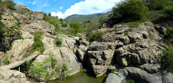 Vista de larga exposición de un río escondido en Crimea, Ucrania. Un conjunto de piedra contra un patrón de agua borrosa es ideal para el uso de fondo. —  Fotos de Stock