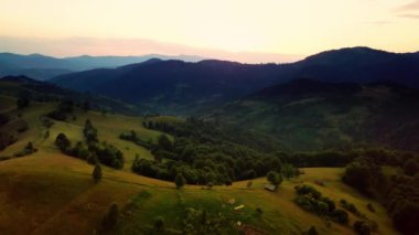 Karpatlar 'ın uçsuz bucaksız otlaklarının ve tarım arazilerinin havadan görünüşü. Tarım tarlası. Gün batımında kırsal dağ manzarası. Ukrayna.