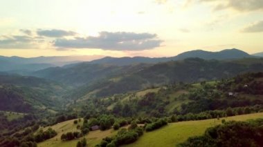 Karpatlar 'ın uçsuz bucaksız otlaklarının ve tarım arazilerinin havadan görünüşü. Tarım tarlası. Gün batımında kırsal dağ manzarası. Ukrayna.