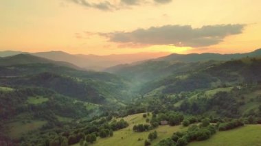 Karpatlar 'ın uçsuz bucaksız otlaklarının ve tarım arazilerinin havadan görünüşü. Tarım tarlası. Gün batımında kırsal dağ manzarası. Ukrayna.