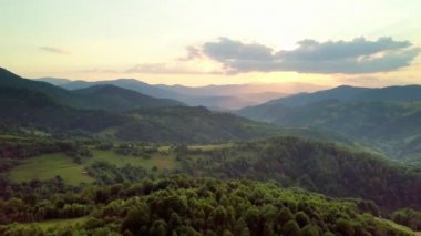 Karpatlar 'ın uçsuz bucaksız otlaklarının ve tarım arazilerinin havadan görünüşü. Tarım tarlası. Gün batımında kırsal dağ manzarası. Ukrayna.