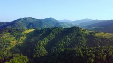 Karpatlar 'ın uçsuz bucaksız otlaklarının ve tarım arazilerinin havadan görünüşü. Tarım tarlası. Gün batımında kırsal dağ manzarası. Ukrayna.