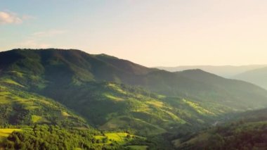 Karpatlar 'ın uçsuz bucaksız otlaklarının ve tarım arazilerinin havadan görünüşü. Tarım tarlası. Gün batımında kırsal dağ manzarası. Ukrayna.