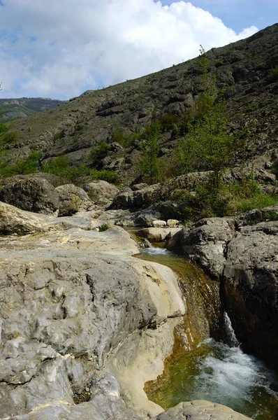 Lange belichting uitzicht van een verborgen rivier in de Krim, Oekraïne. Een steen tegen een wazig waterpatroon is ideaal voor achtergrondgebruik. — Stockfoto