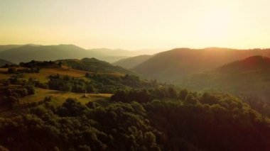 Karpatlar 'ın uçsuz bucaksız otlaklarının ve tarım arazilerinin havadan görünüşü. Tarım tarlası. Gün batımında kırsal dağ manzarası. Ukrayna.