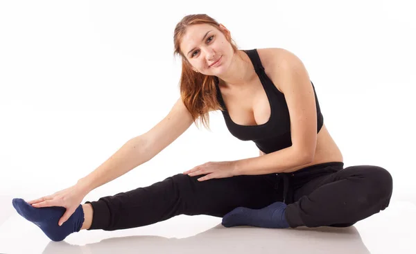 Женская фитнес-модель, тренирующаяся в студии с гантелями и выполняющая упражнения на растяжках и подтяжках на коврике . — стоковое фото