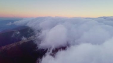 4K İHA bulutlarda uçuyor. Güneş doğarken bulutların arasından uçmak, İHA 'dan bulutların en üst görüntüsü. Ulusal Park Shipit Karpat. Karpatlar, Pylypets, Ukrayna. 