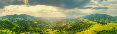 Karpatlar 'ın uçsuz bucaksız otlaklarının ve tarım arazilerinin havadan görünüşü. Tarım tarlası. Gün batımında kırsal dağ manzarası. Ukrayna.