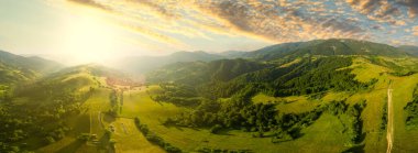 Karpatlar 'ın uçsuz bucaksız otlaklarının ve tarım arazilerinin havadan görünüşü. Tarım tarlası. Gün batımında kırsal dağ manzarası. Ukrayna.
