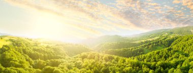 Karpatlar 'ın uçsuz bucaksız otlaklarının ve tarım arazilerinin havadan görünüşü. Tarım tarlası. Gün batımında kırsal dağ manzarası. Ukrayna.