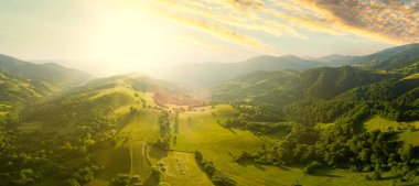 Karpatlar 'ın uçsuz bucaksız otlaklarının ve tarım arazilerinin havadan görünüşü. Tarım tarlası. Gün batımında kırsal dağ manzarası. Ukrayna.