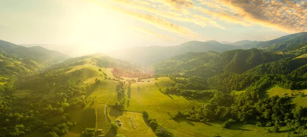 Karpatlar 'ın uçsuz bucaksız otlaklarının ve tarım arazilerinin havadan görünüşü. Tarım tarlası. Gün batımında kırsal dağ manzarası. Ukrayna.