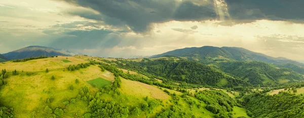 Légi felvétel a Kárpátok végtelen buja legelőiről és a mezőgazdasági területekről. Termesztett mezőgazdasági terület. Vidéki hegyvidéki táj naplementekor. Ukrajna. — Stock Fotó