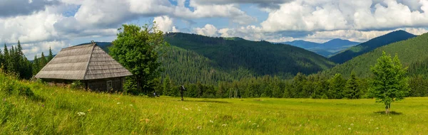 Piękna przyroda i wspaniały krajobraz wokół drewnianej chaty, na polanie położonej na zboczach Karpat nad jeziorem Synevyr. Ukraina. — Zdjęcie stockowe