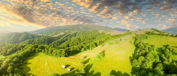 Karpatlar 'ın uçsuz bucaksız otlaklarının ve tarım arazilerinin havadan görünüşü. Tarım tarlası. Gün batımında kırsal dağ manzarası. Ukrayna.