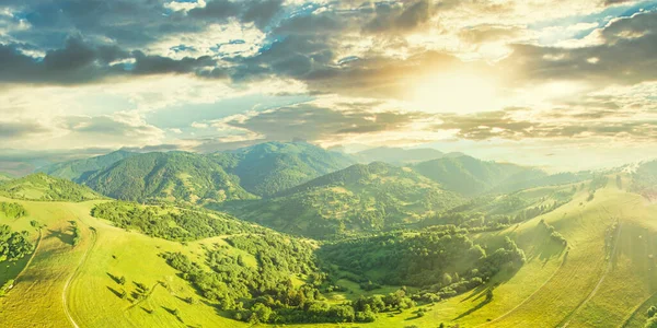 Aerial view of the endless lush pastures of the Carpathian expanses and agricultural land. Cultivated agricultural field. Rural mountain landscape at sunset. Ukraine. — Stock Photo, Image