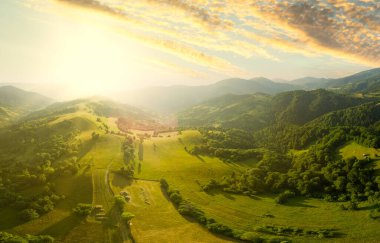 Karpatlar 'ın uçsuz bucaksız otlaklarının ve tarım arazilerinin havadan görünüşü. Tarım tarlası. Gün batımında kırsal dağ manzarası. Ukrayna.
