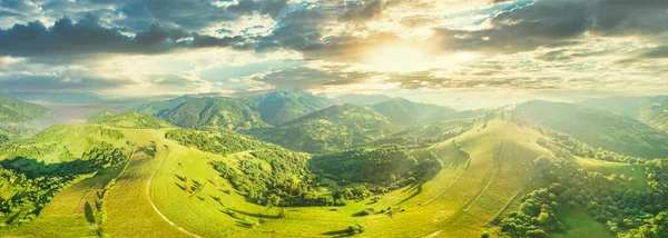 Vista aérea das pastagens exuberantes intermináveis das extensões dos Cárpatos e das terras agrícolas. Campo agrícola cultivado. Paisagem montanhosa rural ao pôr do sol. Ucrânia. — Fotografia de Stock