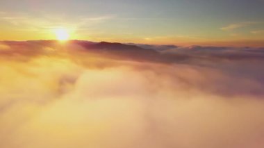 4K İHA bulutlarda uçuyor. Güneş doğarken bulutların arasından uçmak, İHA 'dan bulutların en üst görüntüsü. Ulusal Park Shipit Karpat. Karpatlar, Pylypets, Ukrayna. 