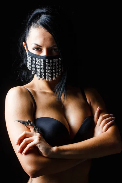 Close-up portrait of beautiful brunette woman with facial body art hiding half of her face with mask — Stock Photo, Image