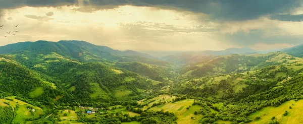 Karpatlar 'ın uçsuz bucaksız otlaklarının ve tarım arazilerinin havadan görünüşü. Tarım tarlası. Gün batımında kırsal dağ manzarası. Ukrayna.