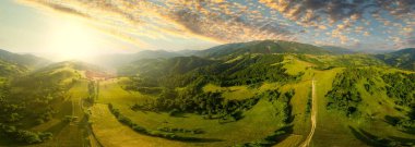 Karpatlar 'ın uçsuz bucaksız otlaklarının ve tarım arazilerinin havadan görünüşü. Tarım tarlası. Gün batımında kırsal dağ manzarası. Ukrayna.